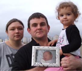 Buncrana couple Toni Stemp and Chris McFadden pictured in the garden of their Carrick Fern home with daughter Alix and a photo of their beloved Shae.